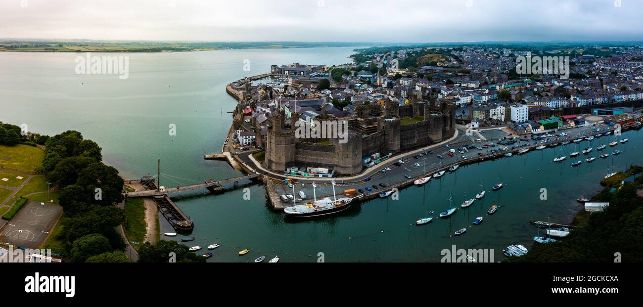Vue aérienne par drone du château de Caernarfon et des remparts le long de la rivière Seiont dans le nord du pays de Galles Banque D'Images