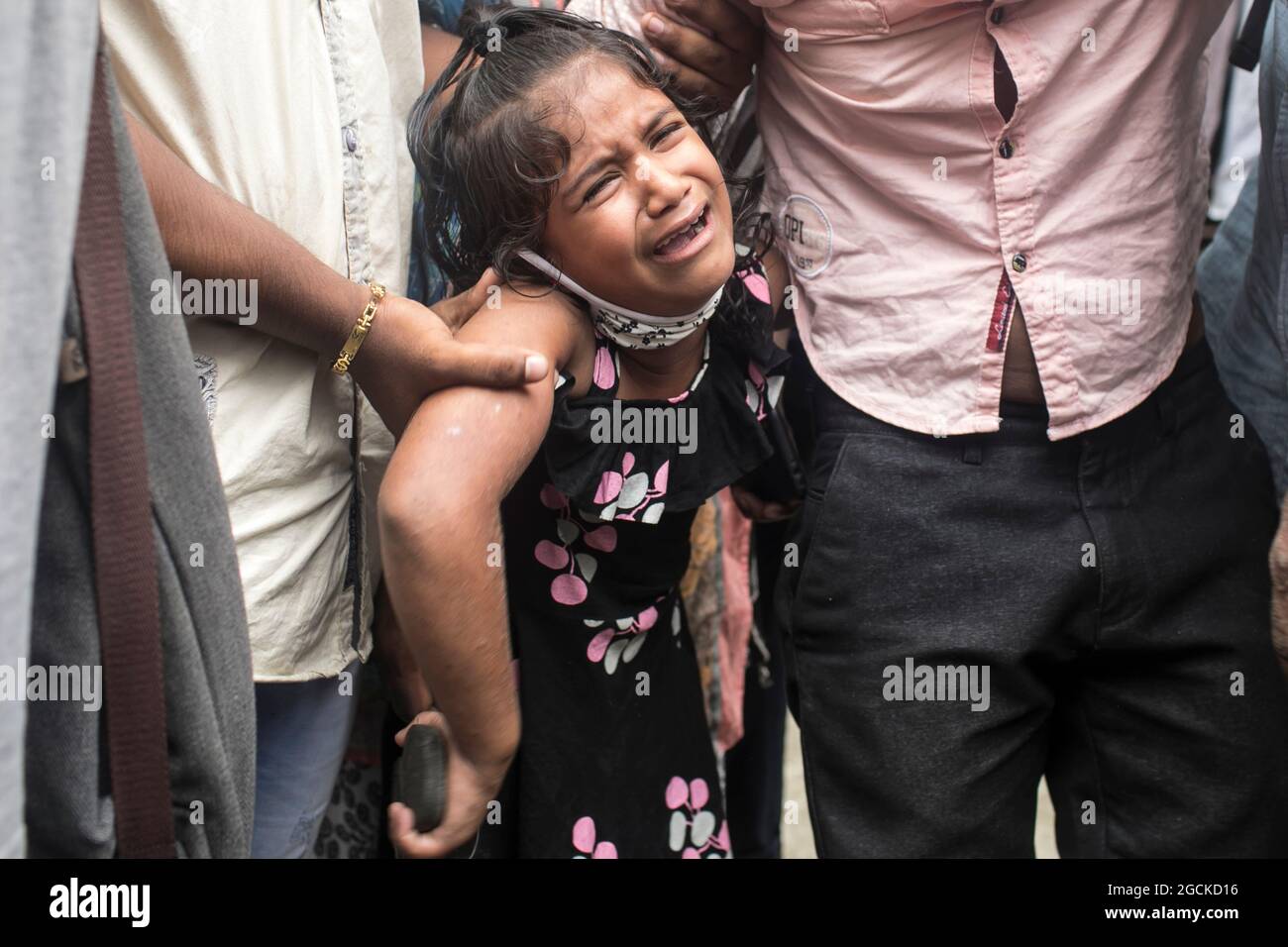 Dhaka, Bangladesh, 7 août : un enfant désarpe, alors qu'il voit tel est livré les restes dans des cercueils, des parents qui sont morts dans l'incendie mortel, qui avait englouti une usine de Narayanganj le mois dernier. Les autorités ont remis les 21 cadavres des travailleurs, qui sont morts dans l'incendie de l'usine de Hashem Foods Ltd à Rupganj de Narayanganj, le 8 juillet dernier. Les corps charrés ont été libérés de 12 h à 13 h après que l'unité judiciaire du Département d'enquête criminelle (CID) de la police ait identifié 45 travailleurs décédés sur 48 par analyse d'ADN. Cependant, CID doit encore confirmer les identités de trois autres Banque D'Images