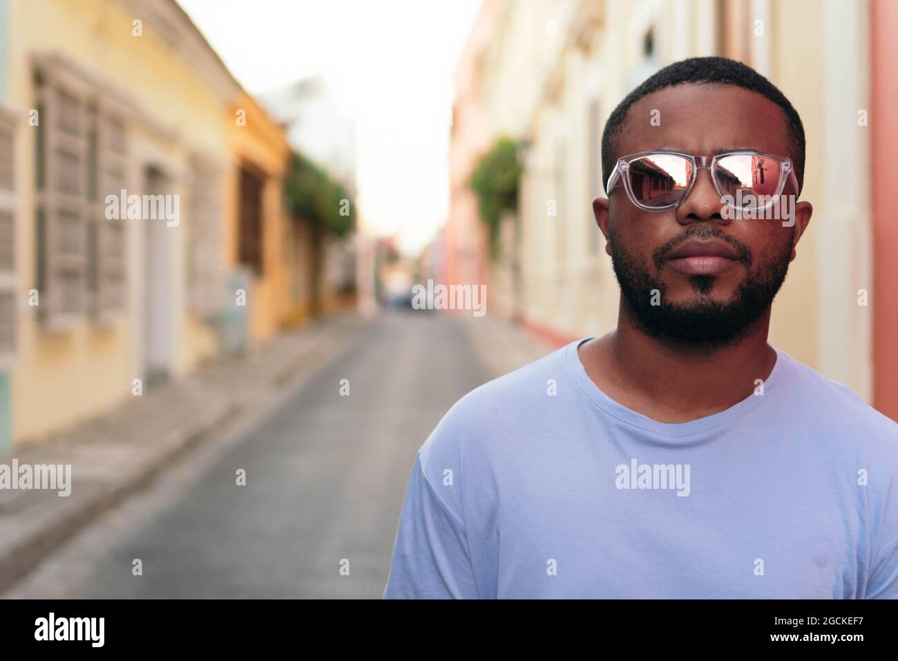 Portrait de l'homme afro-américain élégant marchant avec des lunettes de  soleil à l'extérieur. Homme noir à la mode dans la rue Photo Stock - Alamy