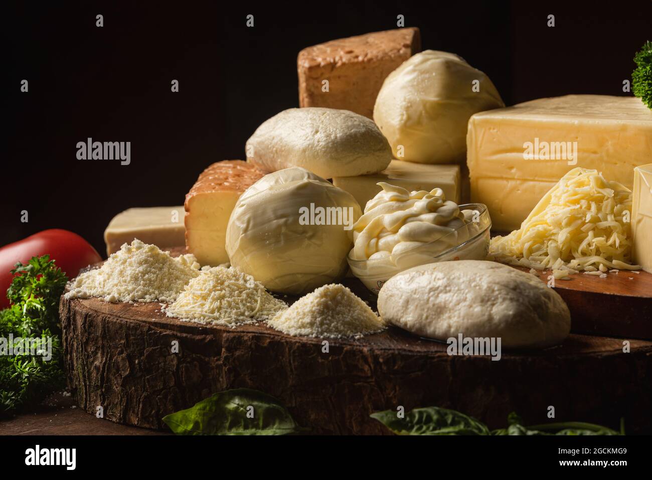 Collecte de fromage italien sur table avec légumes frais et persil plat avec feuilles de basilic sur spatules Banque D'Images