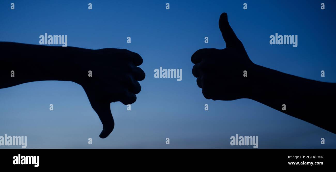 Pouce vers le haut et pouce vers le bas. Deux mains montrant des gestes différents. Oui ou pas de silhouette. Aime et n'aime pas le signe. Choix. D'accord ou pas d'accord. Banque D'Images