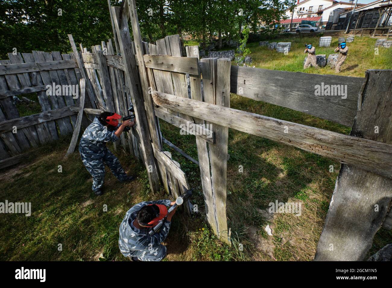 Par dessus les équipes avec des joueurs en vêtements de camouflage jouant paintball et visant à d'autres pendant le match Banque D'Images