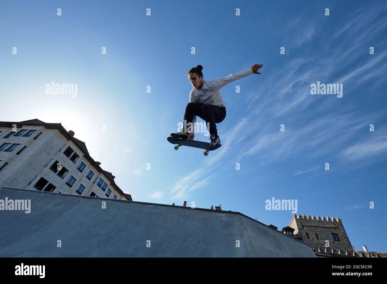 De dessous de jeune homme courageux skieur saut avec le skateboard et  exécution de cascades dans le parc de skate le jour ensoleillé contre le  ciel bleu Photo Stock - Alamy
