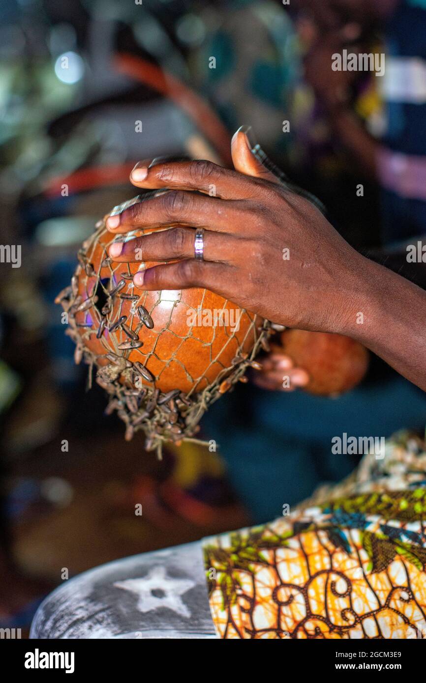 UN HOMME JOUE UN INSTRUMENT DE MUSIQUE AFRICAIN, LE SHEKERE. Banque D'Images