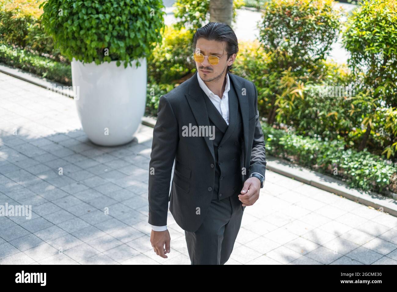 Portrait de l'homme réussi en costume noir formel et lunettes de soleil jaunes . Photo de haute qualité Banque D'Images