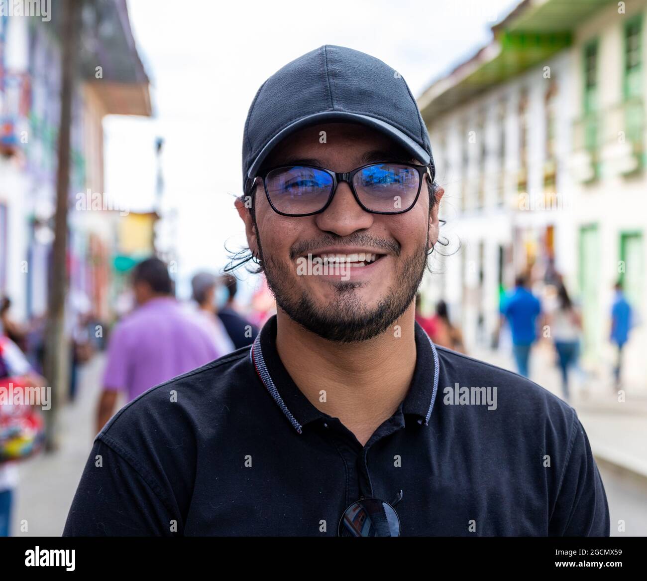 Portrait riant Latino jeune homme avec chapeau et lunettes dans une rue d'une ville à Filandia Quindio Banque D'Images