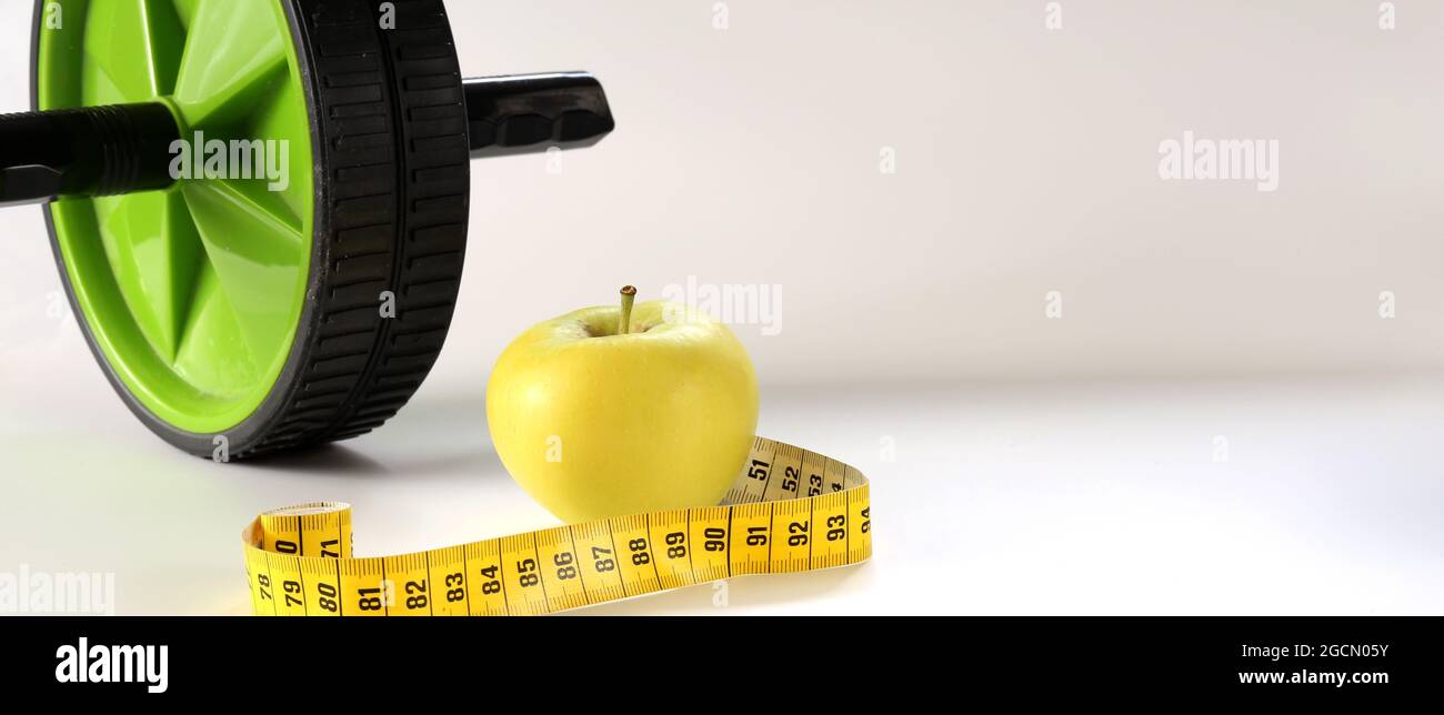 Un style de vie sain. Concept de forme physique et de vie saine. Apple, mètre ruban, sport à la maison équipement de gym ab rouleau pour l'amincissement de régime Banque D'Images