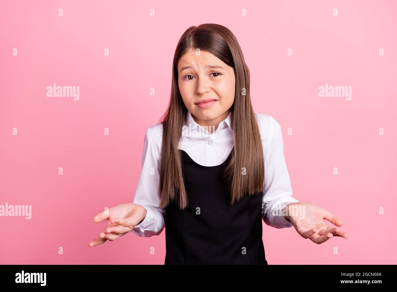 Photo de jeune fille malheureuse sans indice haussement d'épaules porter uniforme aucune idée isolée sur fond de couleur rose Banque D'Images