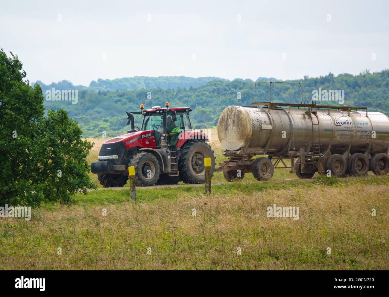 Un tracteur case Puma 340 rouge tracte une remorque hydraulique de 30,000 litres Banque D'Images