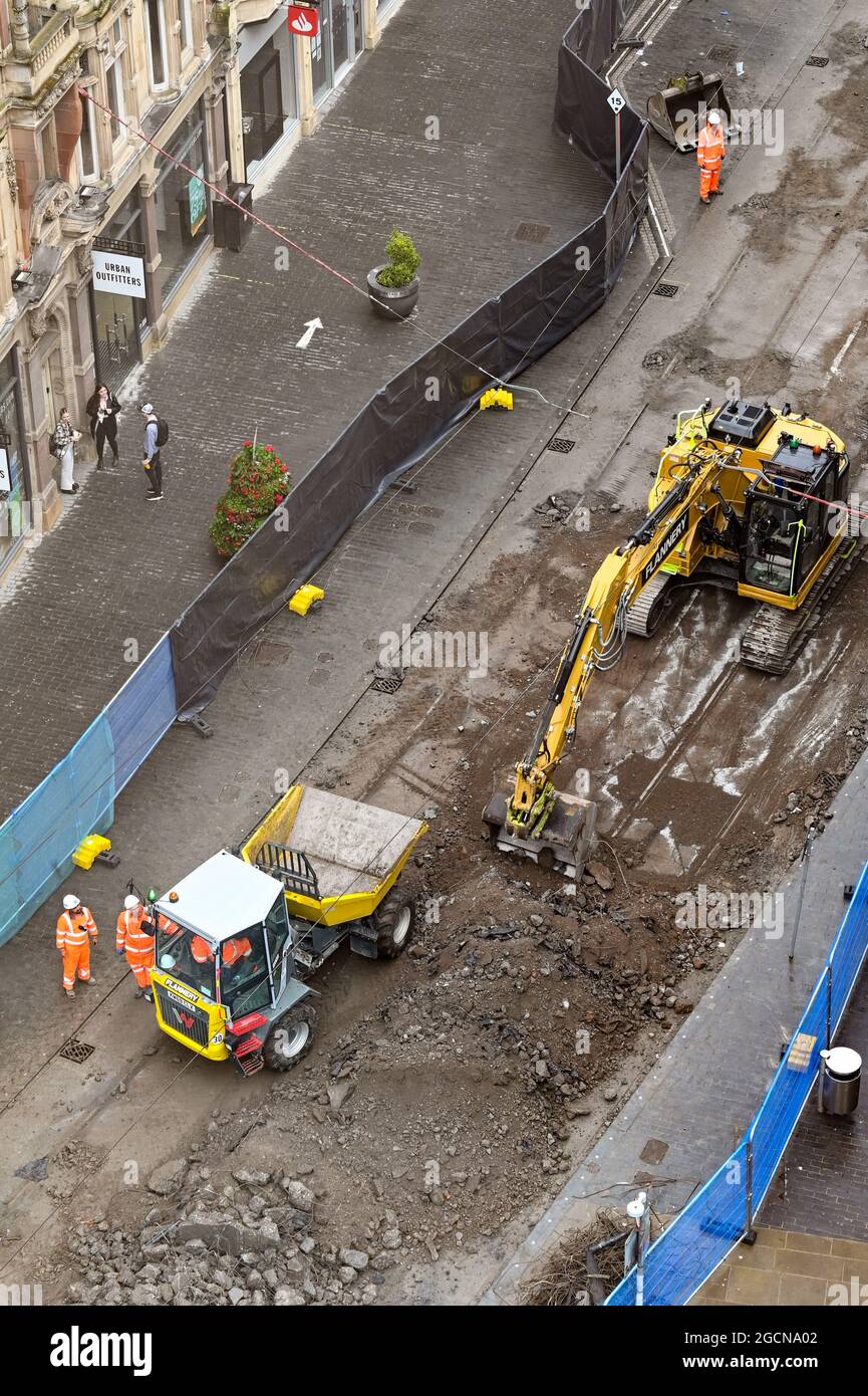 Birmingham, Angleterre - août 2021 : vue aérienne d'une pelle mécanique creusant la route et les voies de tramway dans l'une des rues du centre-ville. Banque D'Images