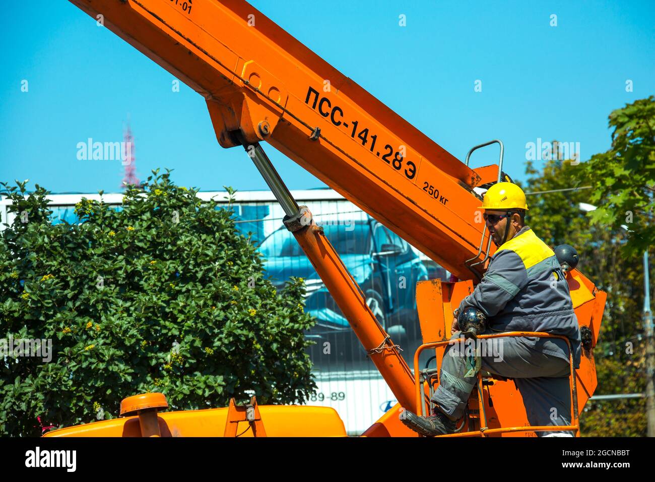 Dnepropetrovsk, Ukraine - 08.06.2021: Un opérateur utilise une grue avec une flèche et un panier pour les travailleurs pour les travaux d'installation en hauteur. Banque D'Images