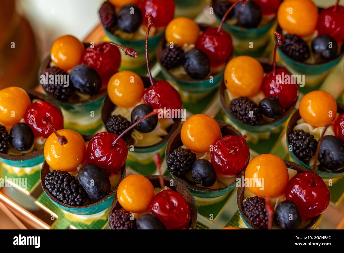 Quatre fruits différents, disposés dans de petits bols sur une table de buffet décorée pour une fête. Banque D'Images