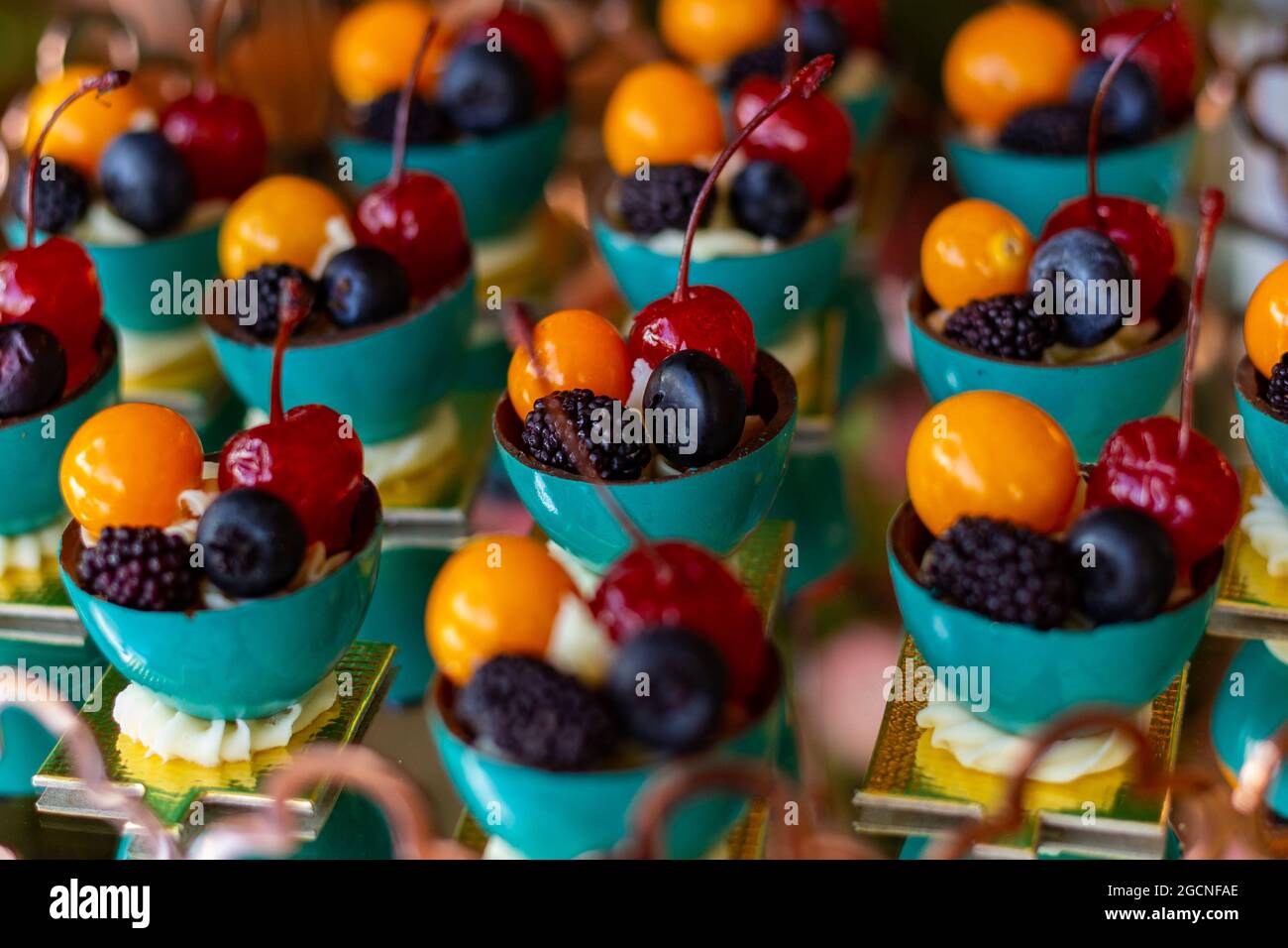 Quatre fruits différents, disposés dans de petits bols sur une table de buffet décorée pour une fête. Banque D'Images