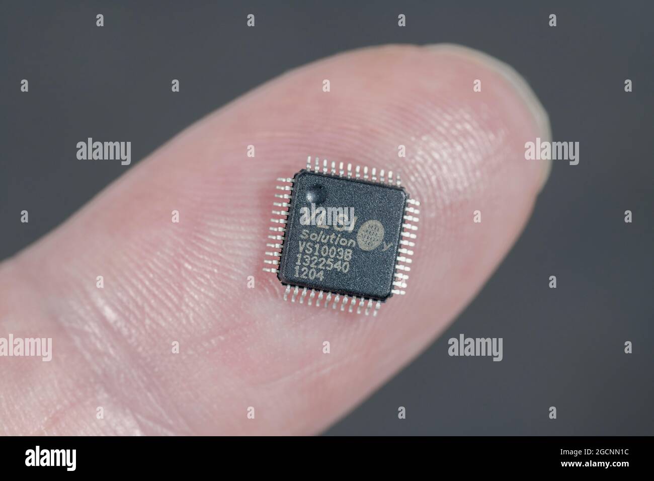 Petit ci de solution VSLI / puce de circuit intégré sur le bloc de doigt montrant la petite taille de composant. Il s'agit d'une puce d'encodeur de codec audio MP3 / WMA. Banque D'Images