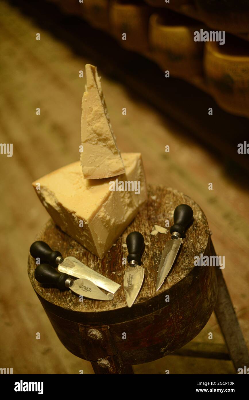 Roue de parmesan sur une planche à découper au journal Banque D'Images