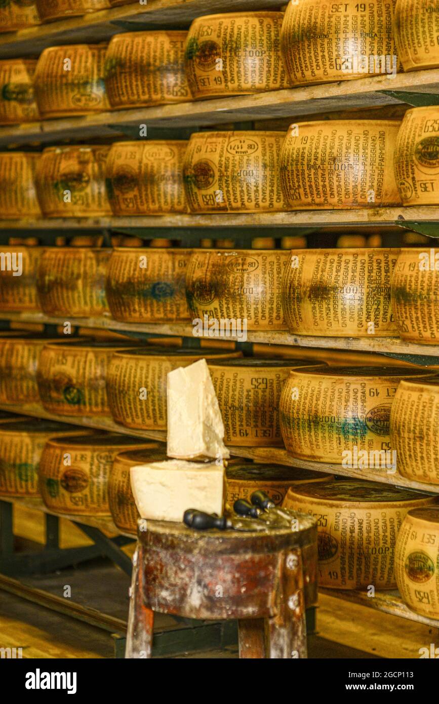 Roue de parmesan sur une planche à découper au journal Banque D'Images