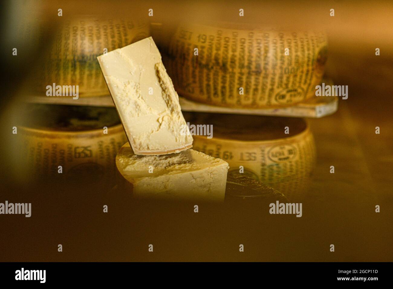 Roue de parmesan sur une planche à découper au journal Banque D'Images