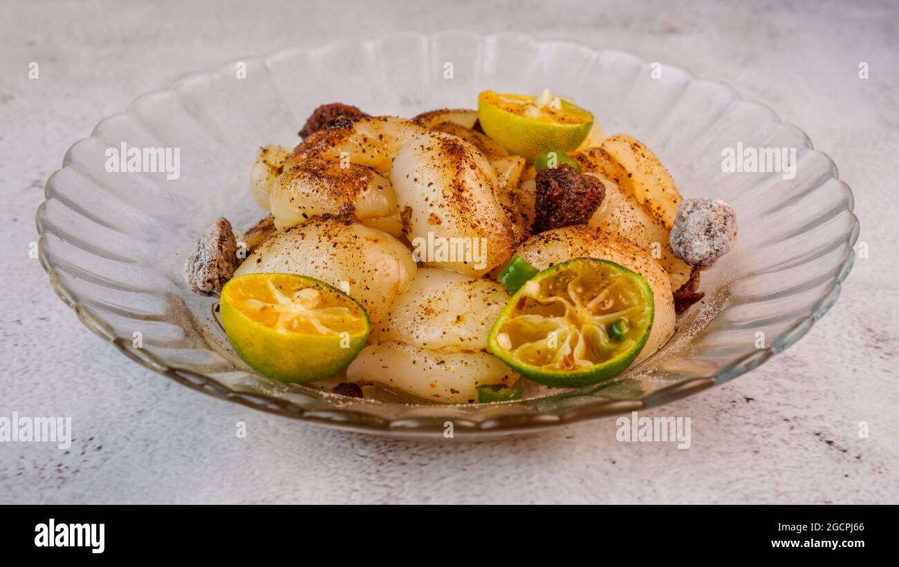 Rambutan mariné avec calamansi, prune aigre et piment des yeux des oiseaux. Cliché de profil isolé. Banque D'Images