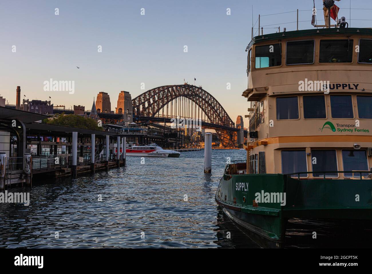 Sydney, Australie - 14 octobre 2020 : les ferries jaunes verts à Circular Quay, Sydney Australie. En arrière-plan, l'immense Harbour Bridge. Coucher de soleil à Banque D'Images