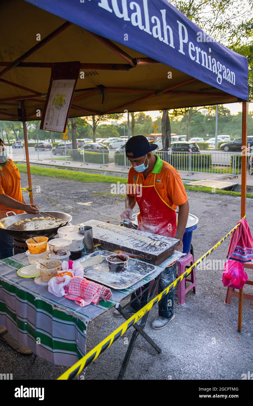 Les jeunes hommes frissent le Youtiao ou le Cakoi, une longue bande de pâte frite dorée. Sur un marché frais en Malaisie cuisine en plein air Banque D'Images