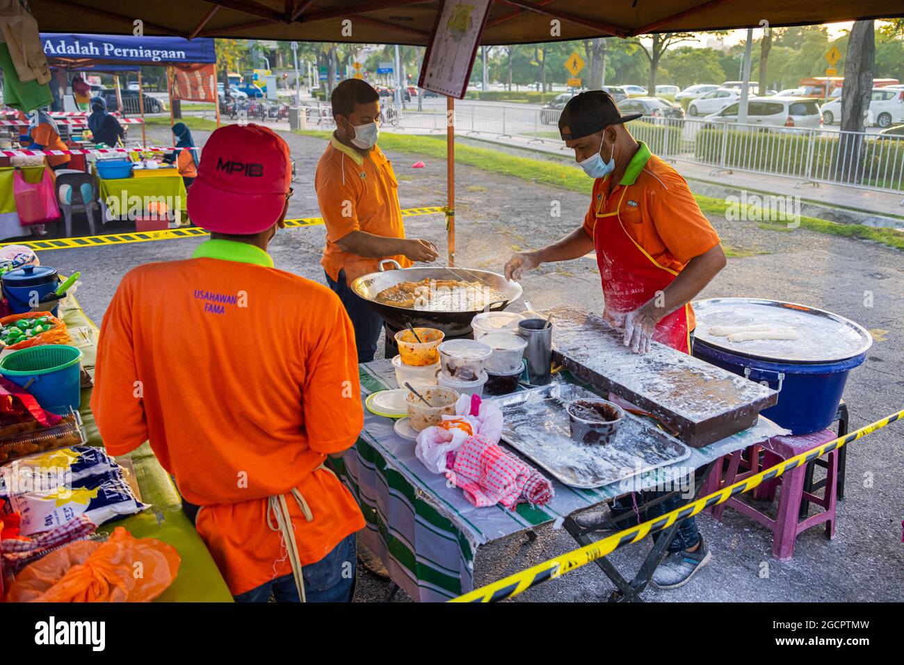 Les jeunes hommes frissent le Youtiao ou le Cakoi, une longue bande de pâte frite dorée. Sur un marché frais en Malaisie cuisine en plein air Banque D'Images