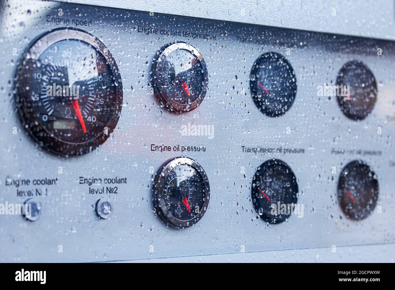 Gouttes de pluie sur la vitre de protection de la planche de bord. Jauges sur le panneau de commande extérieur. Mise au point sélective. Banque D'Images