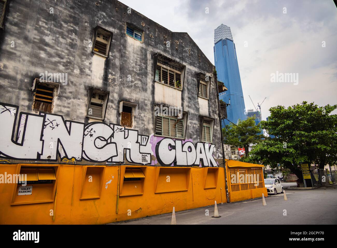 Kuala Lumpur, Malaisie - 04 octobre 2020 : ancienne maison avec graffiti sur les routes arrière de Kuala Lumpur. En arrière-plan le nouveau point de repère de la Malaisie, Banque D'Images