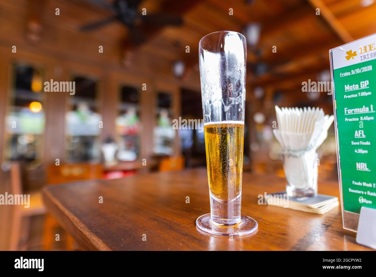 Un gros plan d'une demi-pinte vide de bière pression fraîche. Un verre de bière sur une table en bois dans un pub irlandais En arrière-plan le revêtement en bois du Banque D'Images