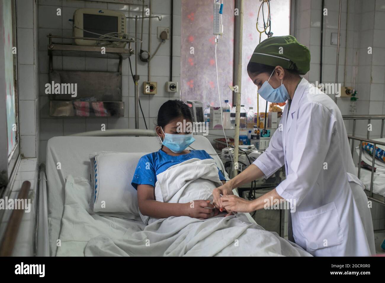 Dhaka, Bangladesh. 08 août 2021. Une infirmière s'occupe d'une fille qui a été infectée par la dengue à l'hôpital pour enfants. Le Bangladesh combat l'épidémie de dengue dans le contexte de la crise de la COVID, une forte augmentation des cas de dengue souche le système de santé du Bangladesh déjà frappé par une aggravation de la crise de la COVID dans le pays. Ce mois-ci, 1,920 personnes ont reçu un diagnostic de la maladie transmise par les moustiques, l'augmentation des patients infectés par la dengue à partir de juin ayant atteint 272 cas. Dhaka, Bangladesh, 8 août 2021. Photo de Sazzad Hossain/Eyepix/ABACAPRESS.COM crédit: Abaca Press/Alay Live News Banque D'Images