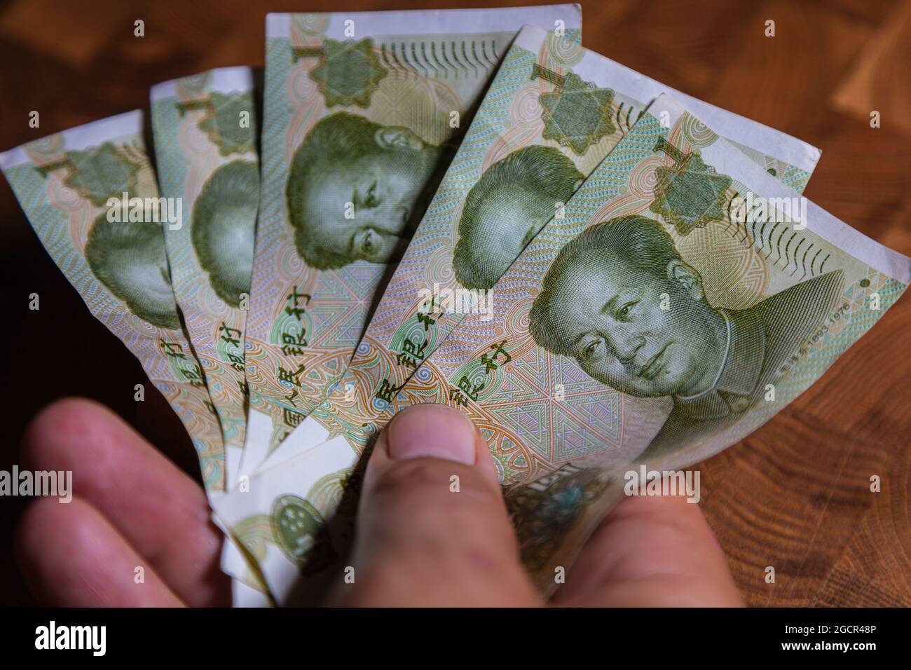 La main masculine tient un fan de 1 renminbi ou yuan chinois ou un billet de banque en RMB abrégé, la monnaie officielle de la république populaire de chine. À l'avant Banque D'Images