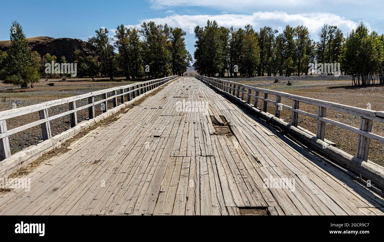 Un vieux pont en bois au-dessus d'une rivière ou d'une crique séchée à la steppe mongole près de la source chaude de Tsetserleg. La condition n'est pas digne de confiance, mais usabl Banque D'Images