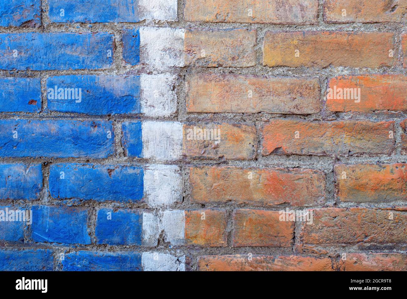 Un mur de briques peint en bleu et blanc Banque D'Images