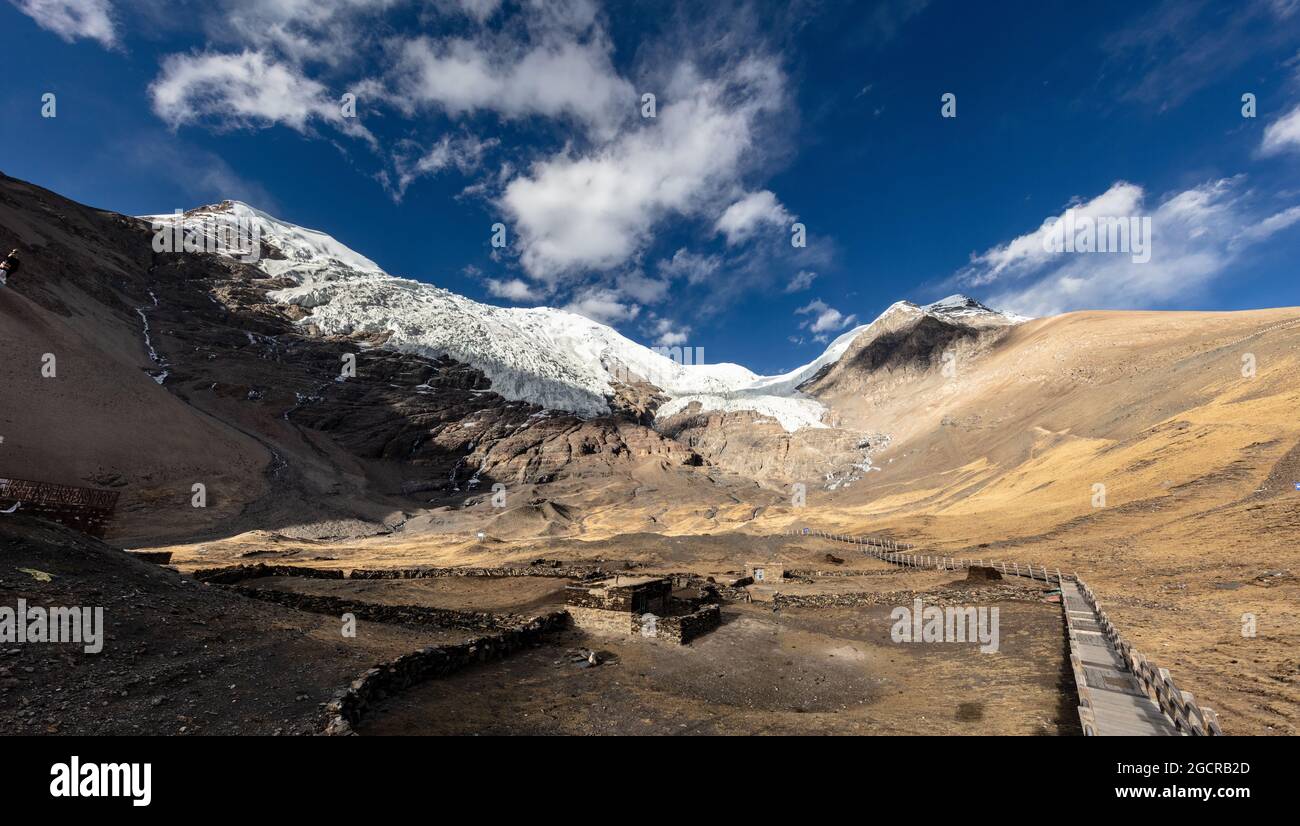 Pic de montagne au Tibet - glacier de kangbu à 5200 mètres au-dessus du niveau de la mer. Nuages blancs et ciel bleu sur les hautes montagnes de l'Himalaya. Neige sur le pic Banque D'Images