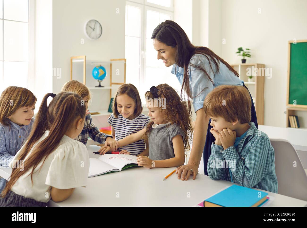 groupe-d-enfants-d-cole-heureux-et-leur-enseignant-ayant-une-classe