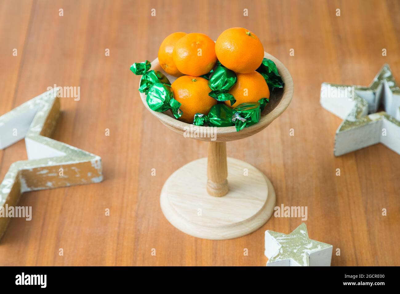 Plateau en bois sur le thème de Noël ou d'anniversaire avec bonbons et mandarines sur la table Banque D'Images
