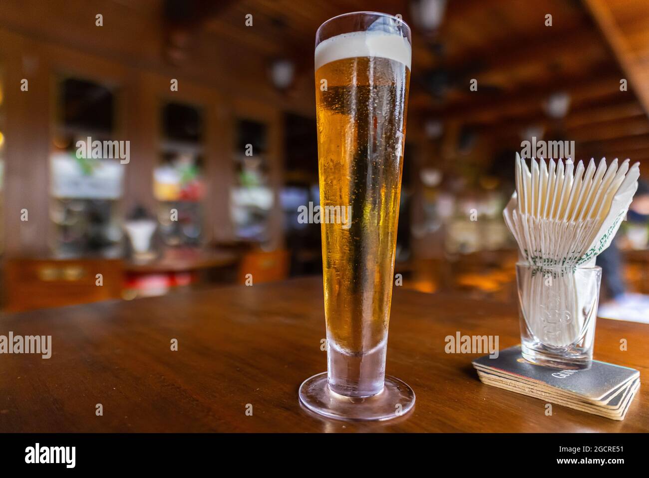 Un gros plan d'une demi-pinte vide de bière pression fraîche. Un verre de  bière sur une table en bois dans un pub irlandais En arrière-plan le  revêtement en bois du Photo Stock -