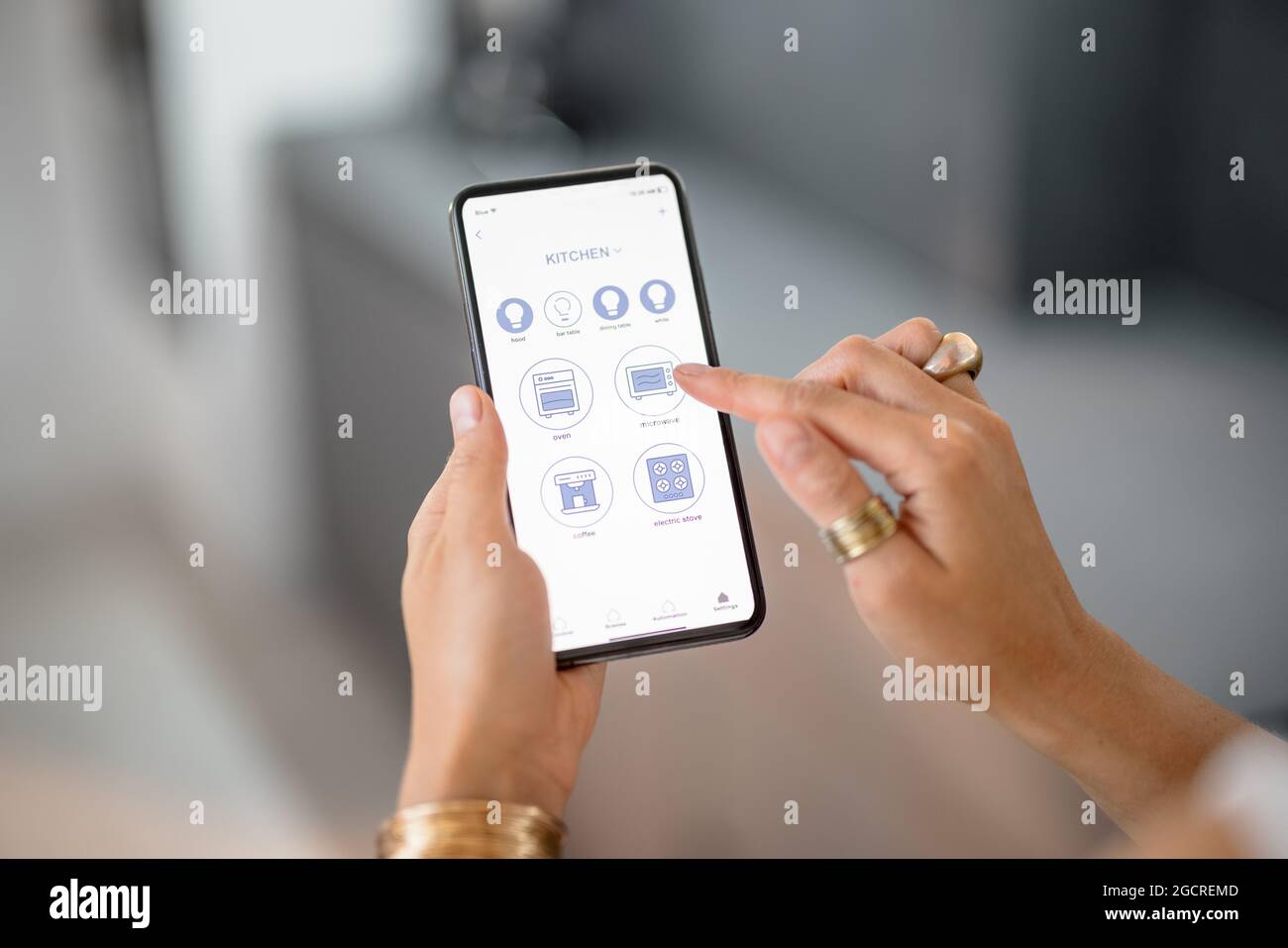 Contrôler les appareils intelligents avec le téléphone dans la cuisine Banque D'Images