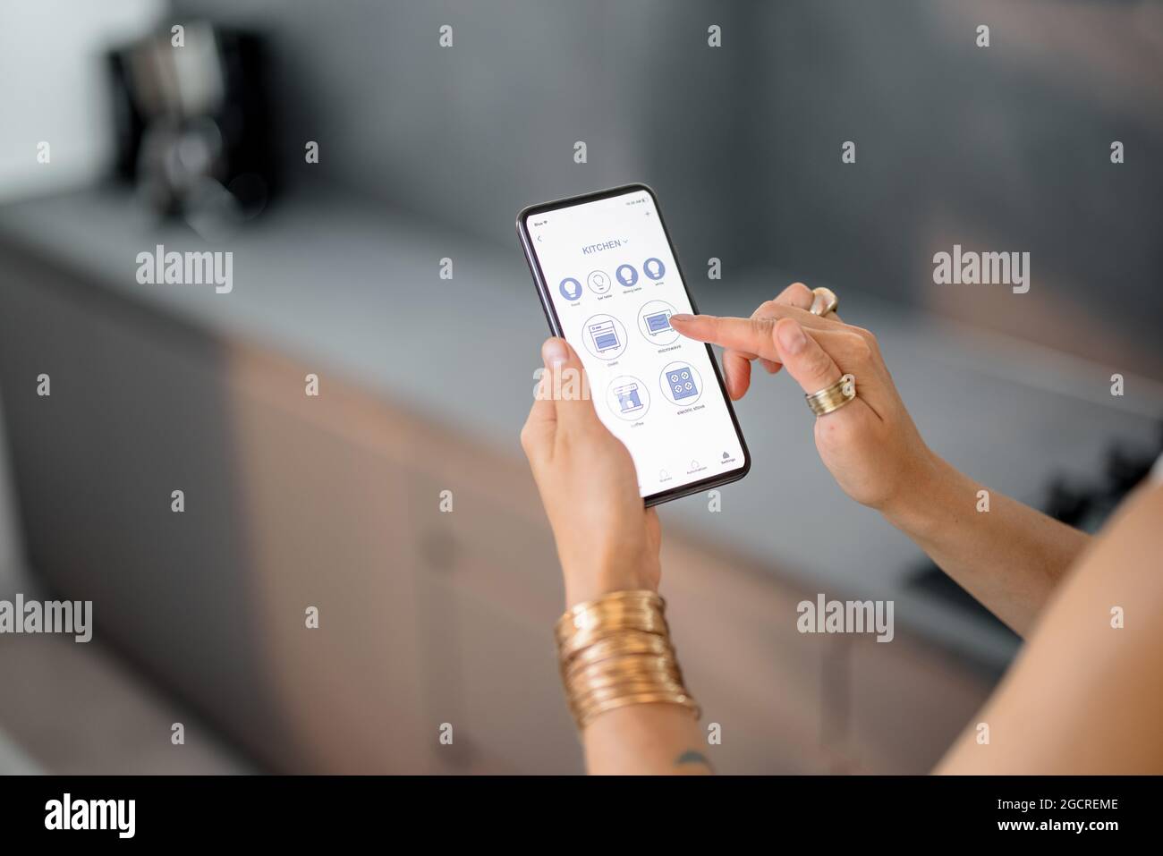 Contrôler les appareils intelligents avec le téléphone dans la cuisine Banque D'Images