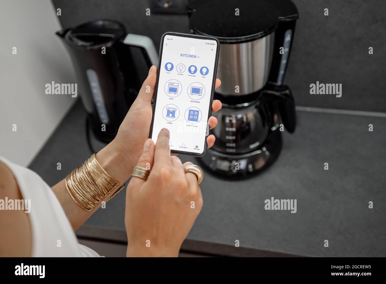 Contrôler les appareils intelligents avec le téléphone dans la cuisine Banque D'Images