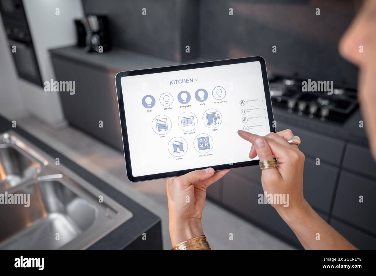 Contrôler les appareils intelligents avec une tablette numérique dans la cuisine Banque D'Images