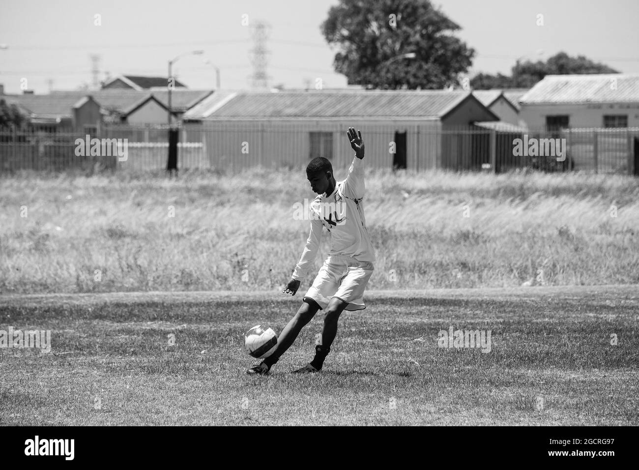 CAPE TOWN, AFRIQUE DU SUD - 05 janvier 2021 : échelle de gris d'un jeune athlète jouant au football à l'école de Cape Town, Afrique du Sud Banque D'Images