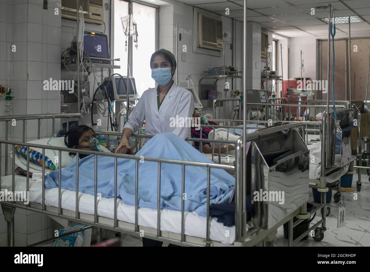 Non exclusif: DHAKA, BANGLADESH - AOÛT 8: Une infirmière s'occupe d'une fille qui a été infectée par la dengue à l'hôpital pour enfants. Le Bangladesh bat deng Banque D'Images