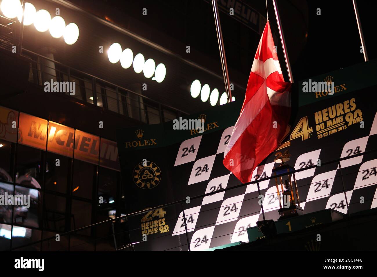 Le podium porte le drapeau danois à mi-mât pour rendre hommage à Allan Simonsen (DEN) Aston Martin Vantage V8, qui a subi un accident mortel dans la course. 24 heures du Mans, samedi 22 juin 2013. Le Mans, France. Banque D'Images