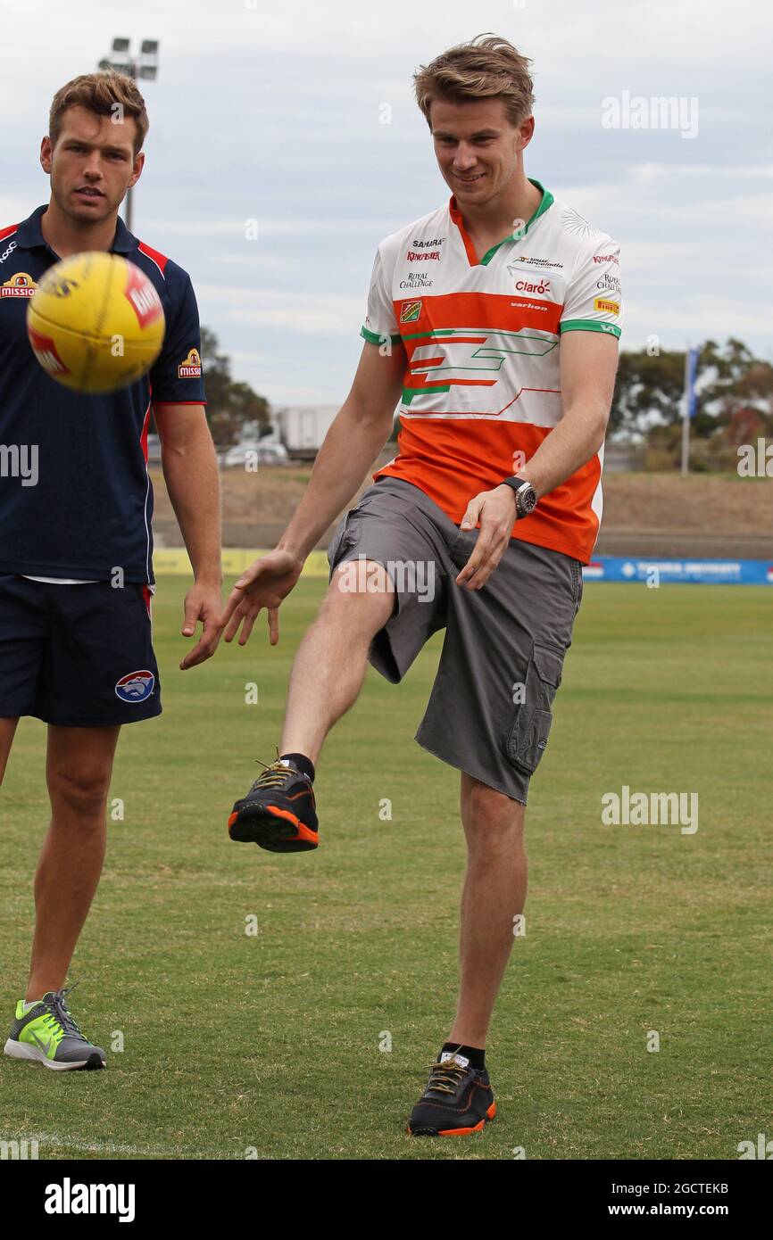 Nico Hulkenberg (GER) Sahara Force India F1 pratique ses compétences dans les règles de l'Australie avec Shaun Higgins (AUS) Western Bulldogs joueur de football australien à Whitten Oval. Grand Prix d'Australie, mardi 11 mars 2014. Albert Park, Melbourne, Australie. Banque D'Images