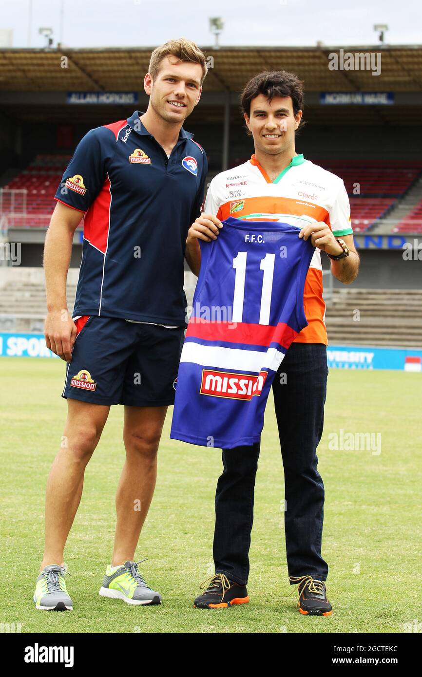 (De gauche à droite) : Shaun Higgins (AUS) Western Bulldogs le footballeur australien présente un maillot d'équipe à Sergio Perez (MEX) Sahara Force India F1 à Whitten Oval. Grand Prix d'Australie, mardi 11 mars 2014. Albert Park, Melbourne, Australie. Banque D'Images