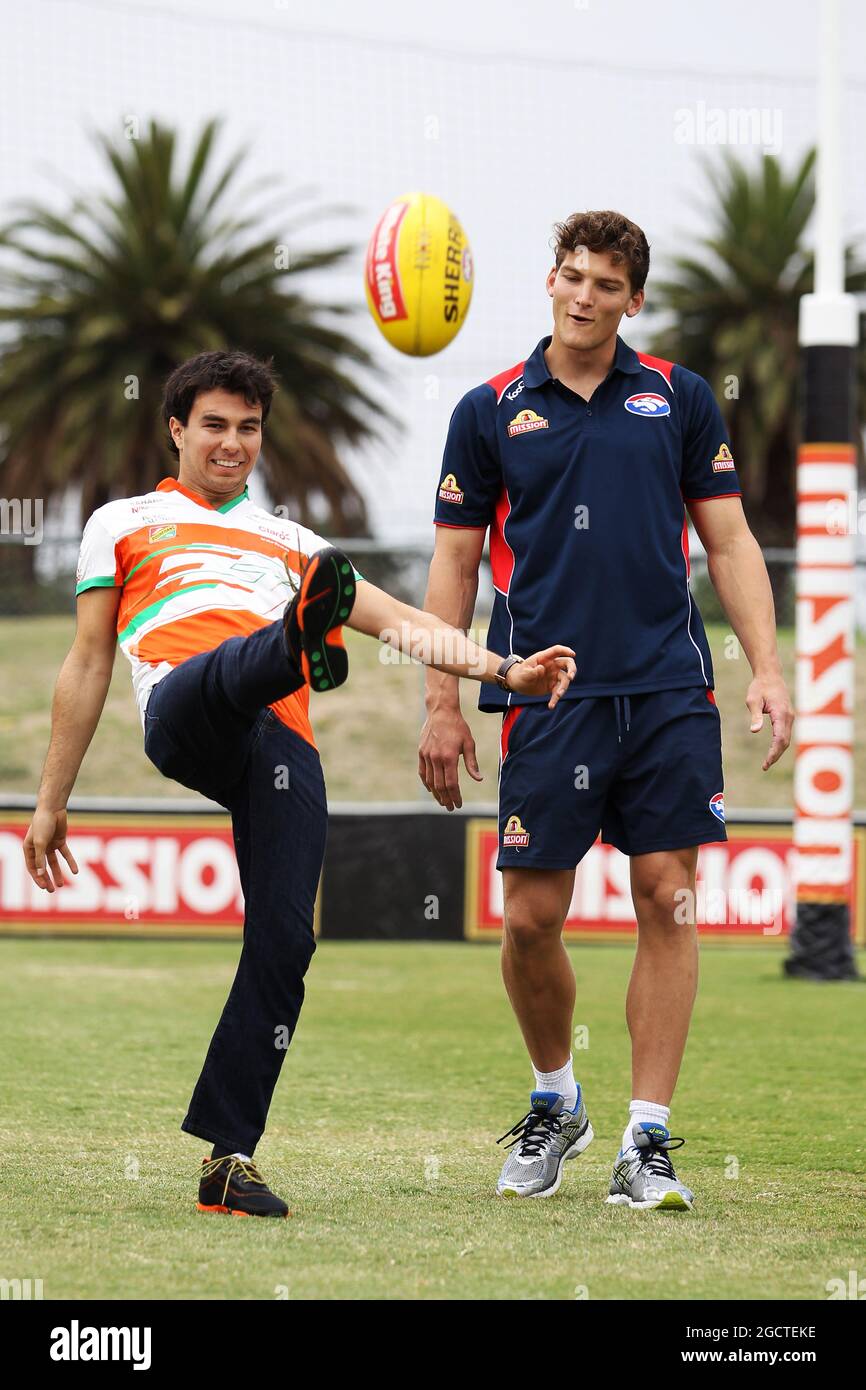 (De gauche à droite) : Sergio Perez (MEX) Sahara Force India F1 pratique ses compétences de règles australiennes avec Wvolonté Minson (AUS) Western Bulldogs footballeur australien à Whitten Oval. Grand Prix d'Australie, mardi 11 mars 2014. Albert Park, Melbourne, Australie. Banque D'Images