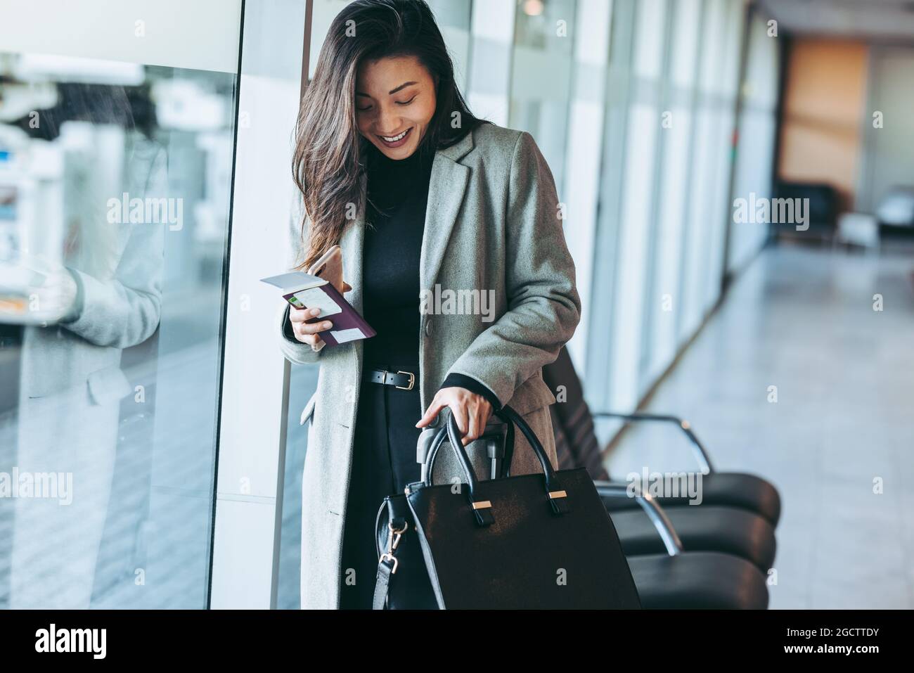 Femme d'affaires avec bagages attendant au terminal de l'aéroport. Femme voyageant seule attendant le vol. Banque D'Images