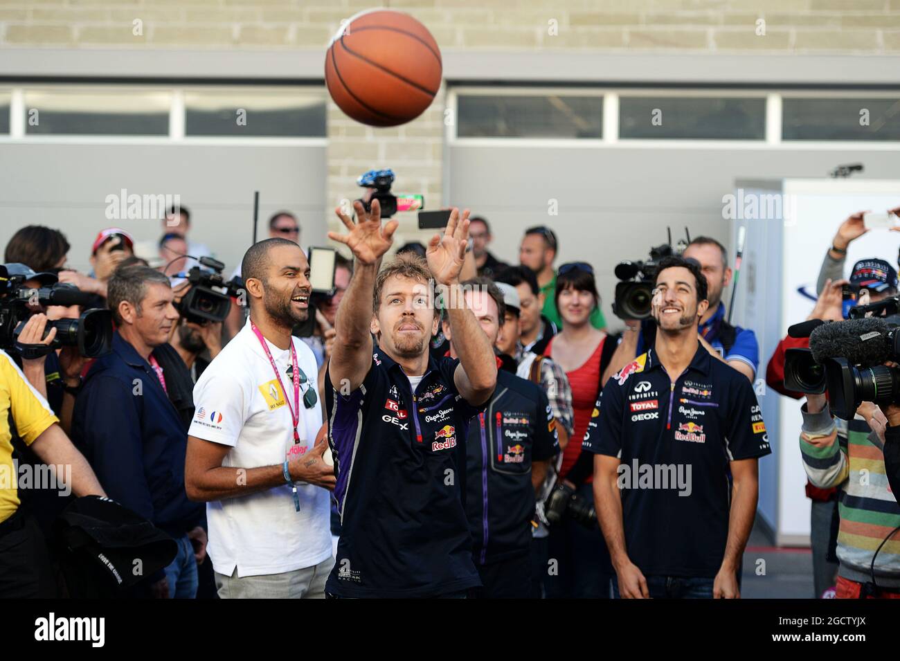 Sebastian Vettel (GER) Red Bull Racing pratique ses compétences de basket-ball avec Tony Parker (FRA) joueur de basket-ball NBA (à gauche); Christian Horner (GBR) Directeur de l'équipe Red Bull Racing et coéquipier Daniel Ricciardo (AUS) Red Bull Racing (à droite). Grand Prix des États-Unis, samedi 1er novembre 2014. Circuit of the Americas, Austin, Texas, États-Unis. Banque D'Images