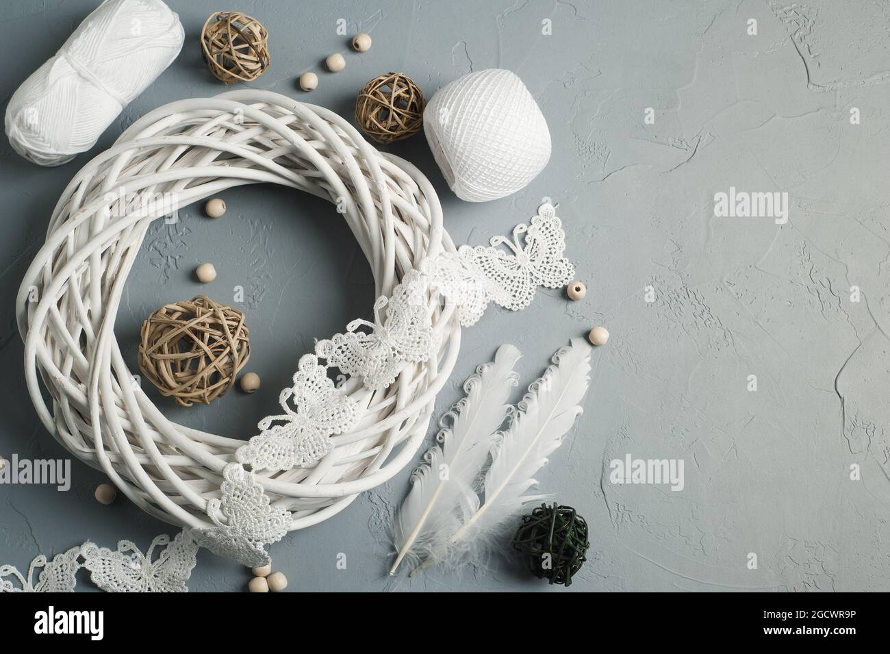 Décoration de Noël avec anneau en osier, lacets, plumes blanches sur fond de béton. Mariage, Noël texture rugueuse plat Banque D'Images