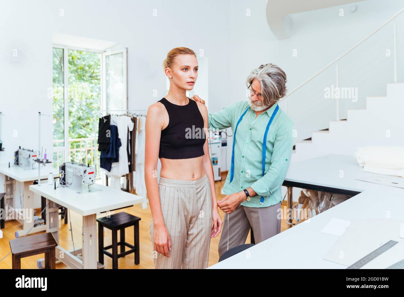 Équipe multiethnique de créateurs de mode travaillant dans un atelier de démarrage de vêtements - groupe multiracial de stylistes, de designers sur mesure et de couturiers travaillant dans Banque D'Images
